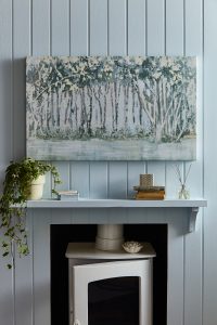 Laura Ashley woodland art above fire place on a light blue wall 