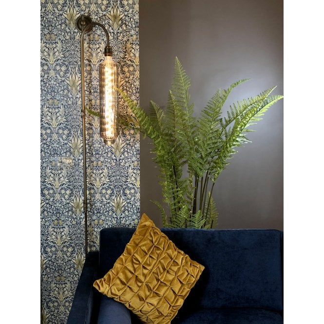 plug in wall light behind a sofa and a pot plant