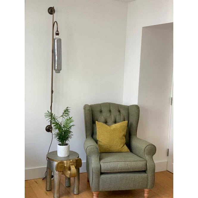 plug in wall light next to armchair and elephant and table lamp