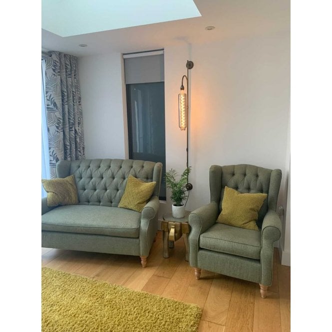 armchair and sofa with plug in wall light.