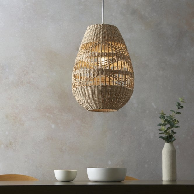 Rattan pendant lighting over a table with bowls and a vase of plants.