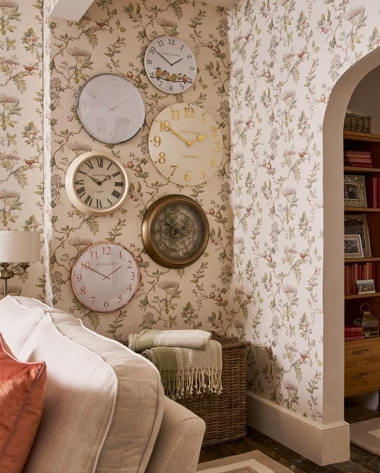 Clocks on a Laura Ashley Wallpaper with a throw underneath
