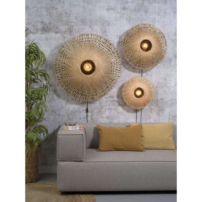 Rattan wall lights set behind a sofa and next to a tall pot plant