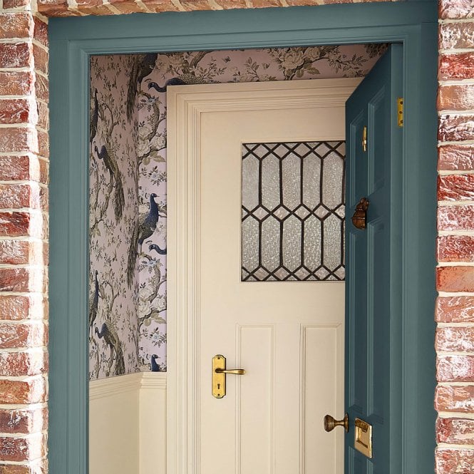 Front door looking into a wallpapered porch. 
