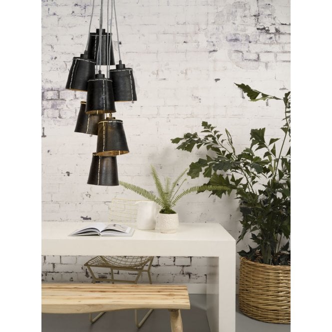 A set of 7 pendant lighting tyers over a table and a large pot plant