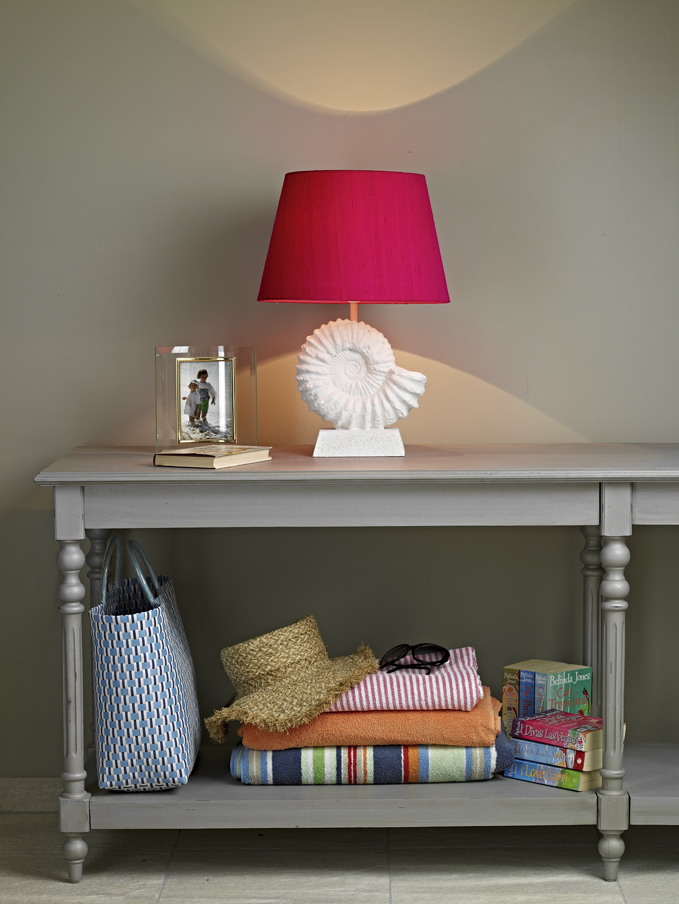 A bright pink fossil table lamp on a side board.