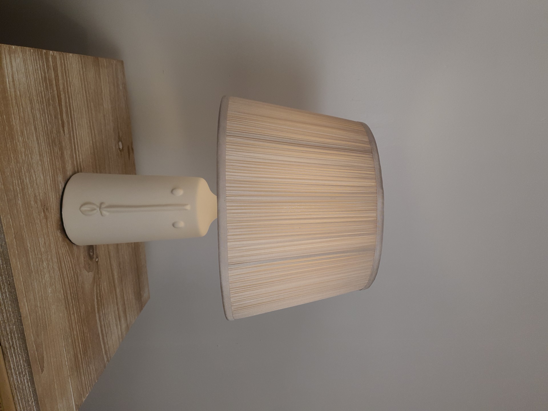 ceramic table lamp with face design on a wooden table.