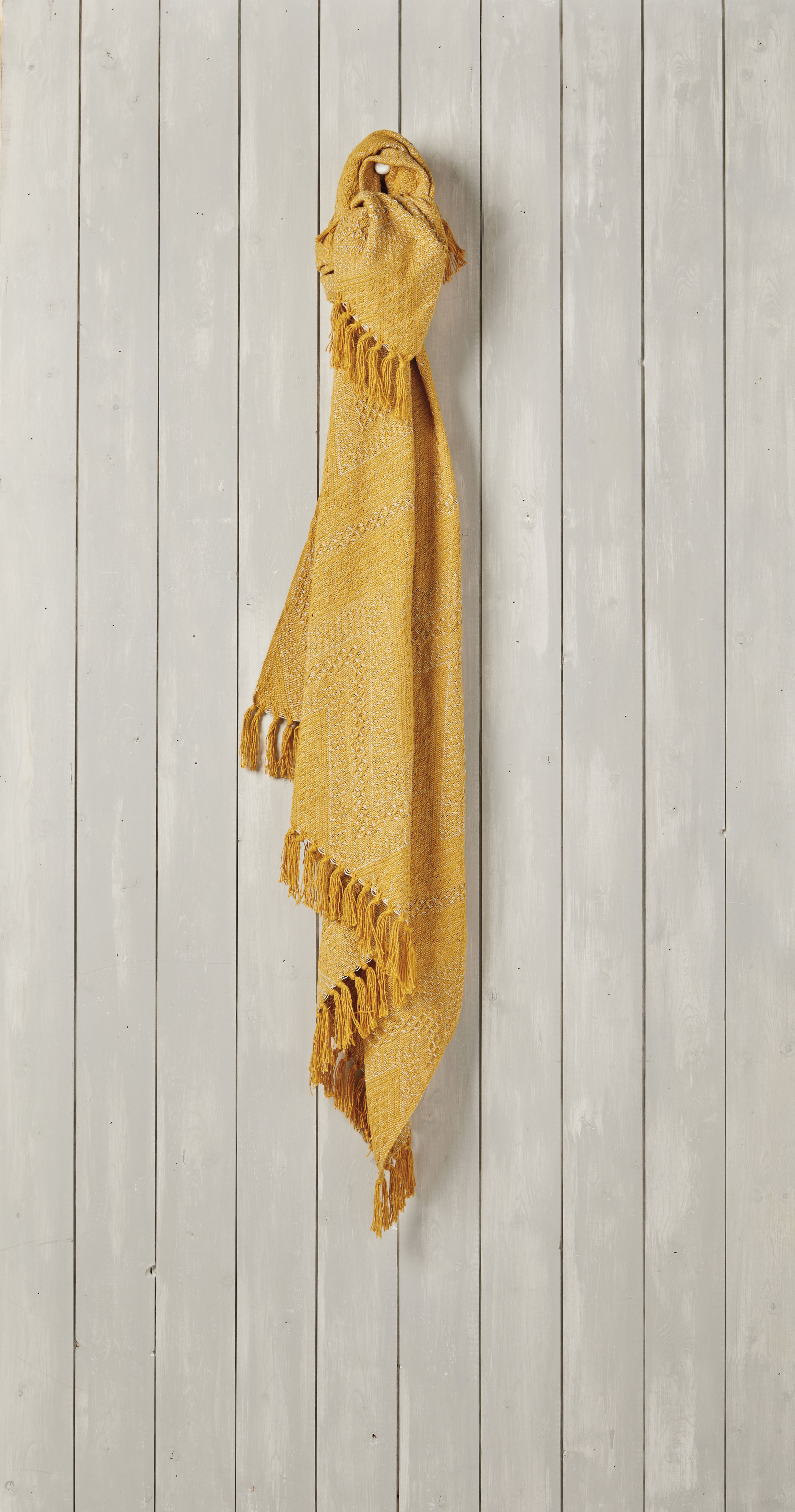 yellow throw hung on a panelled wall.  