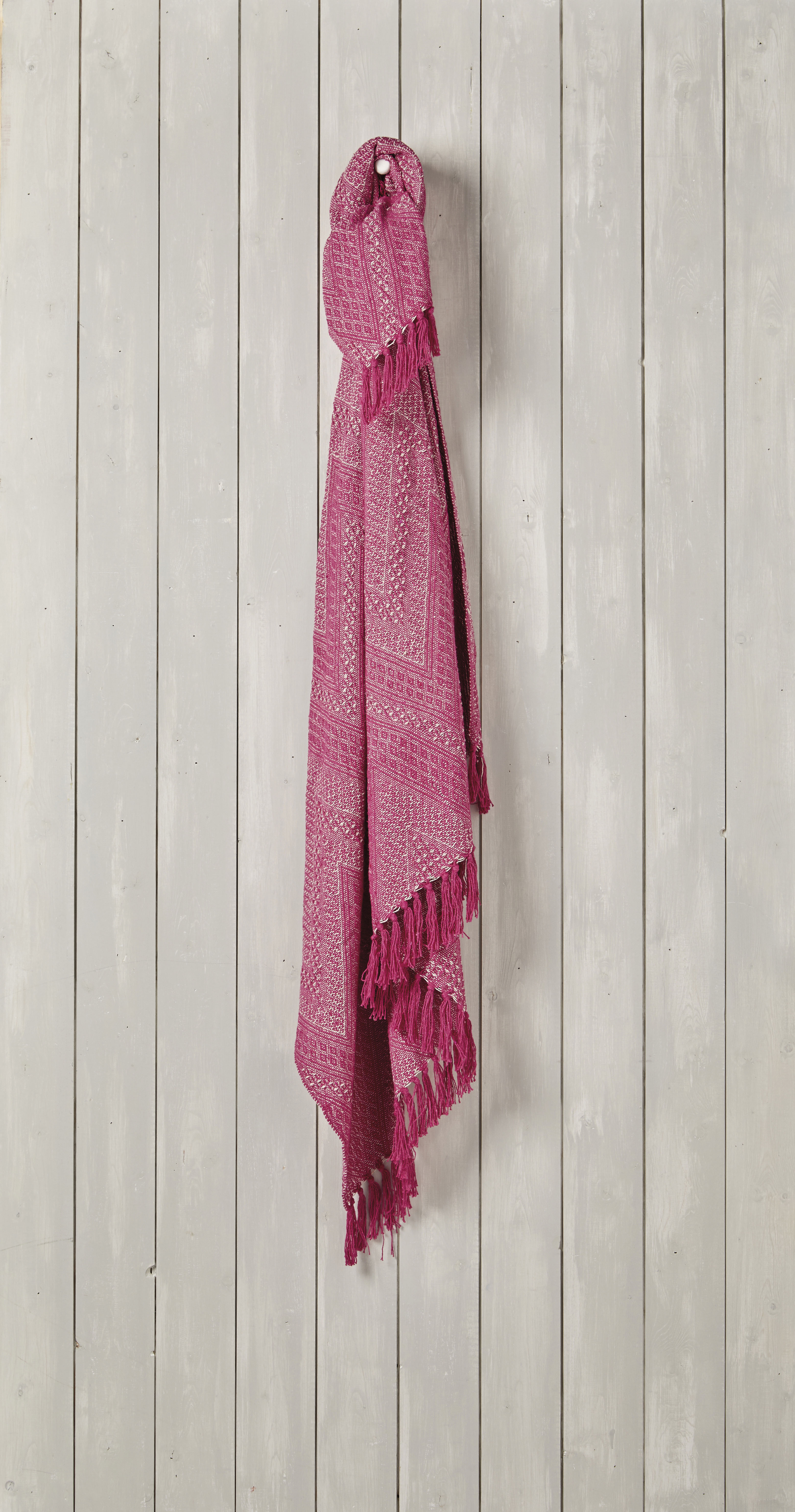 pink throw hung on a panelled wall 
