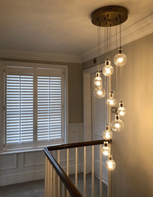 circular plated pendant cluster over a stairwell.