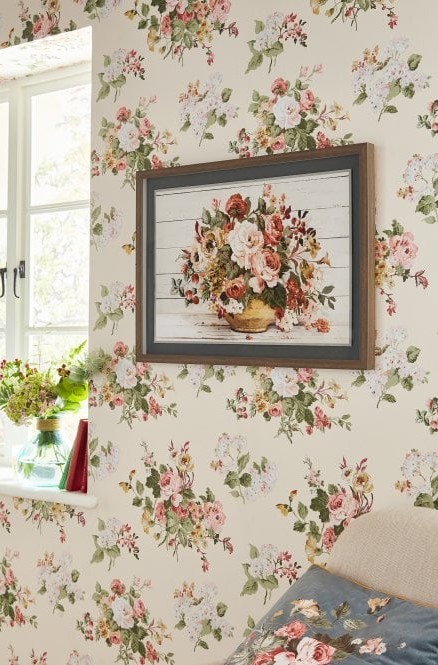 Floral print wallpaper on a wall with a similar wall art hanging on the same wall.