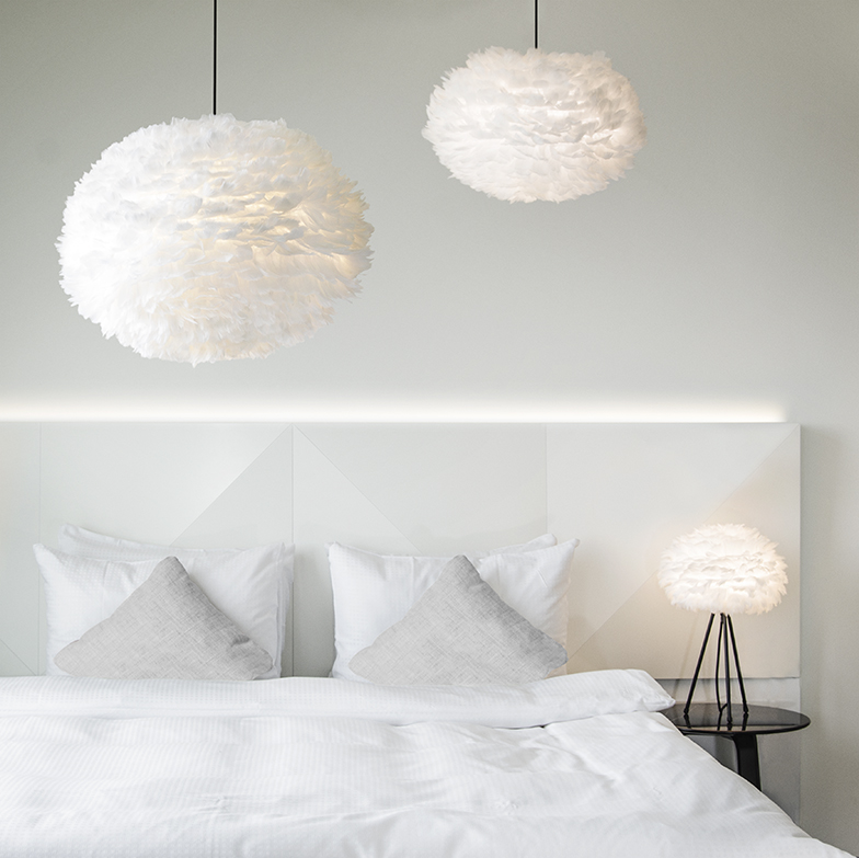 Bedroom with 2 pendant lights hanging over a bed.