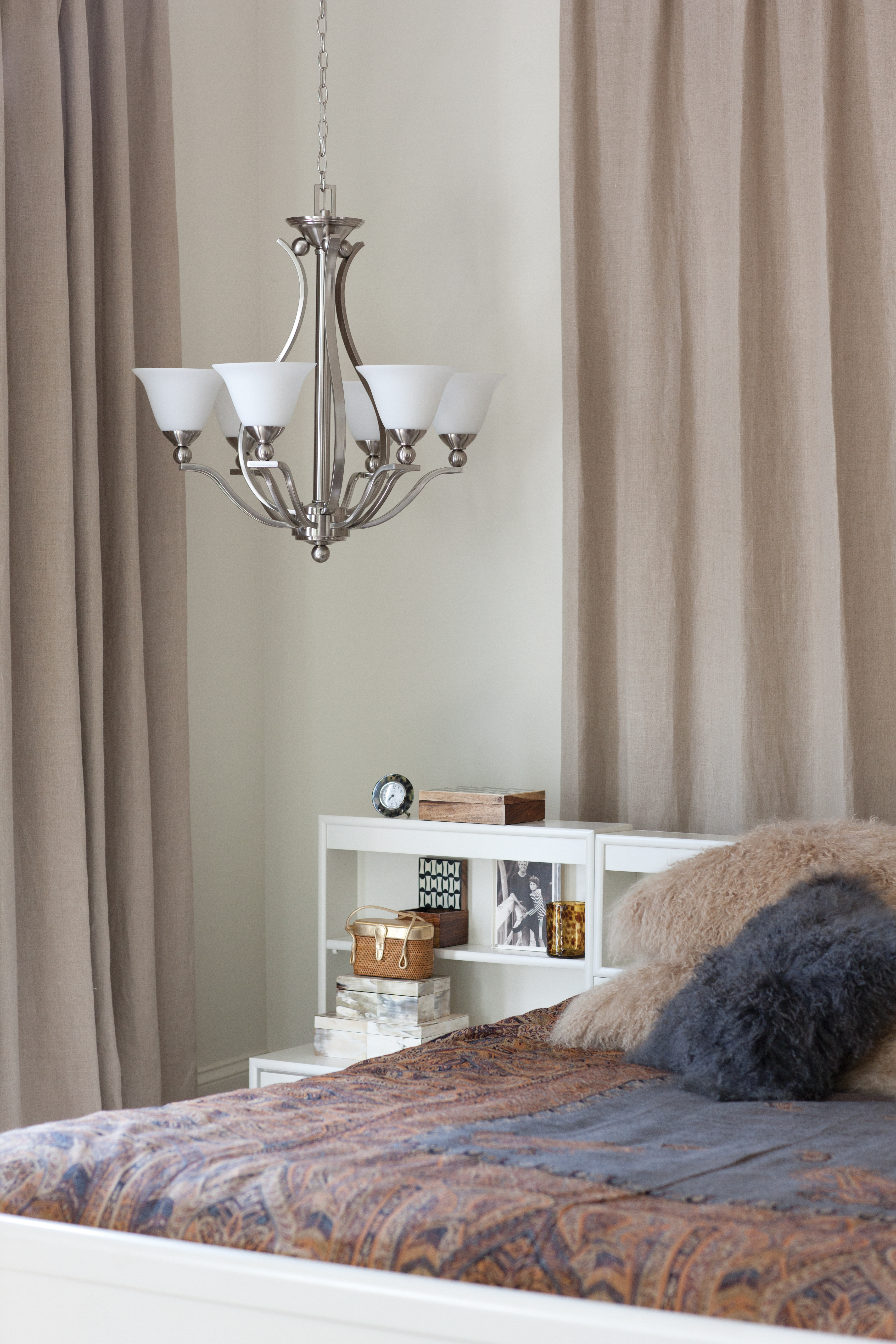 A pendant light hanging next to a bedside.