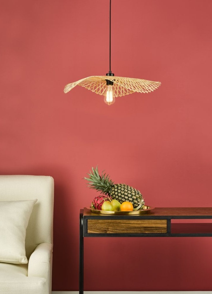 A ceiling light over a cabinet with a bowl of fruit next to a chair.