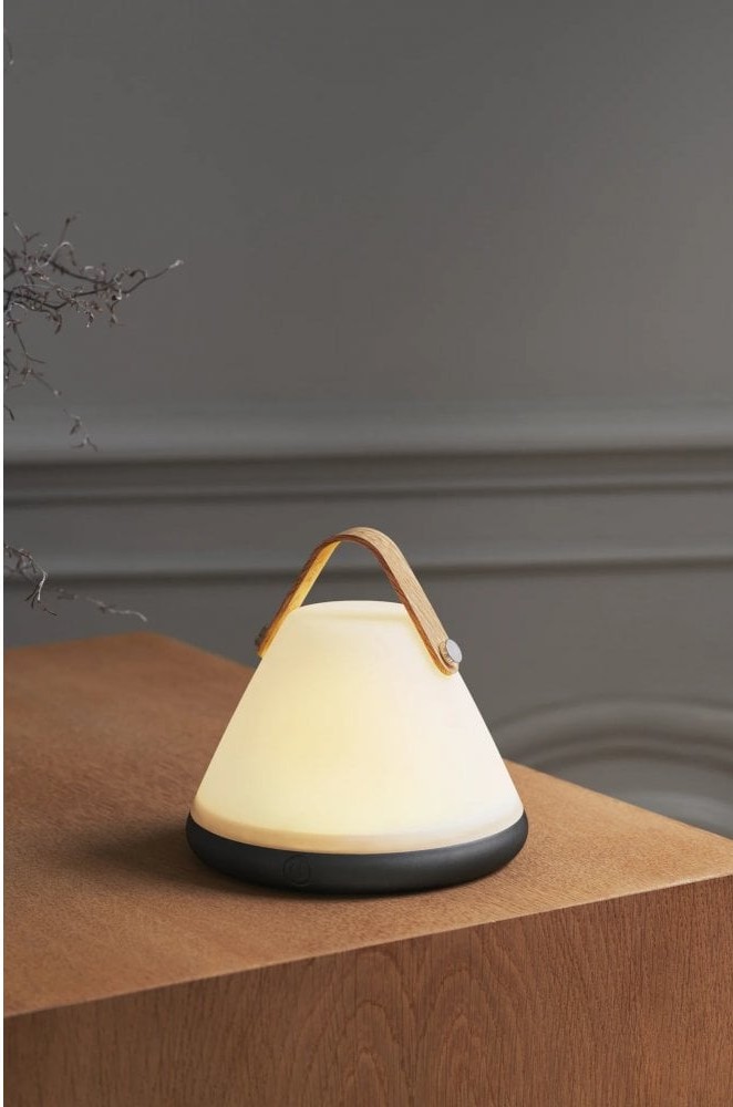 A portable lamp on a side board