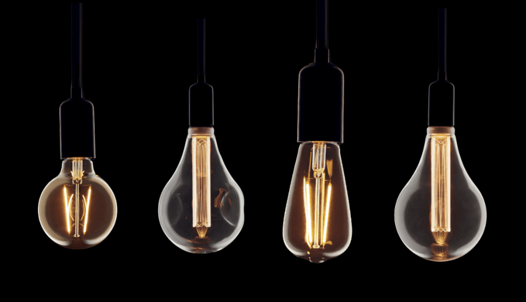 4 different shaped and sized LED bulbs on black background, with lit filament