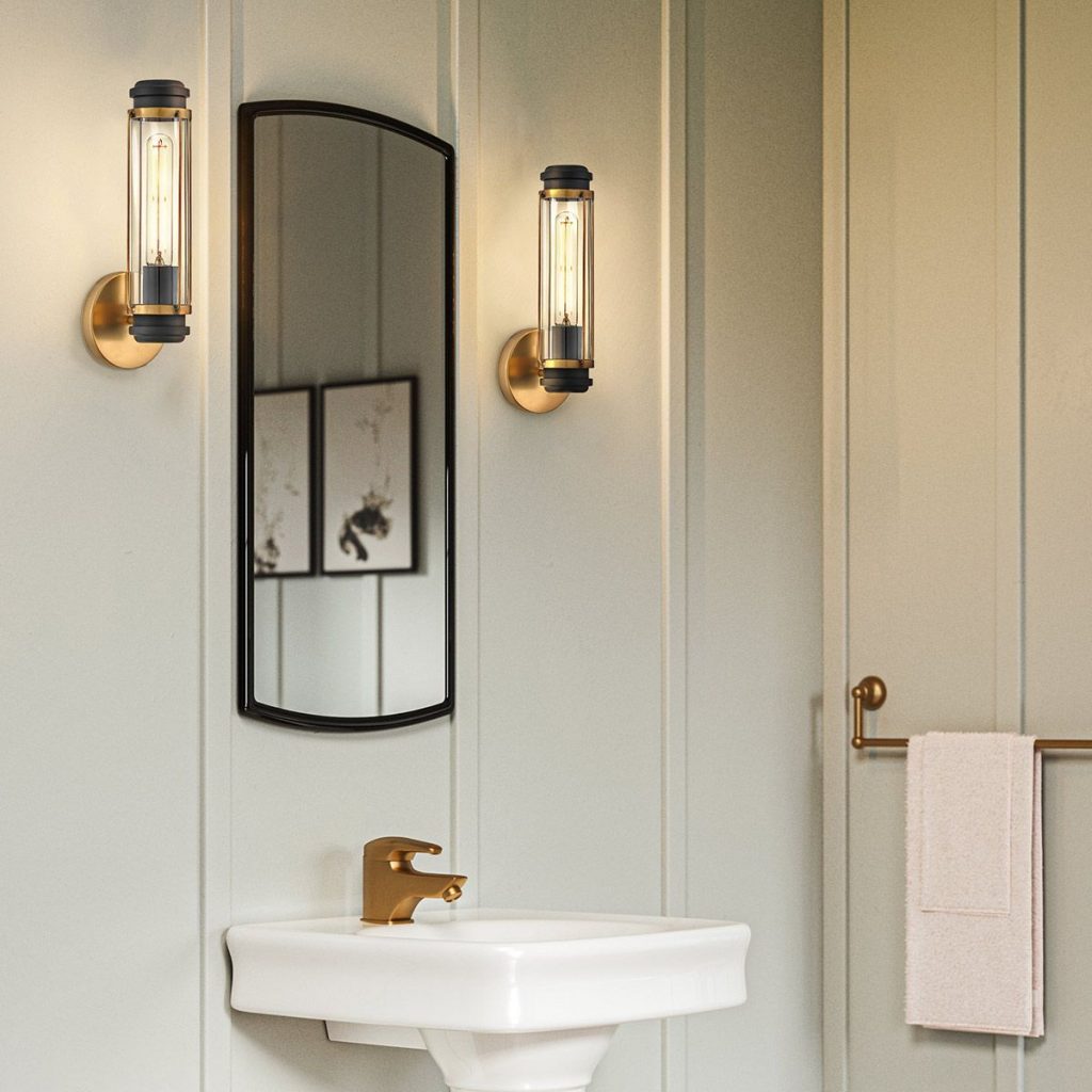 Mixed materials bathroom wall lights in black and gold help unify an brass tap and black mirror.