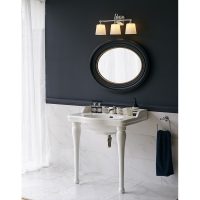 Contrasting black and white bathroom lit by unusual deco wall light