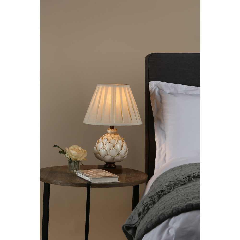 a cream lamp on a bedside table