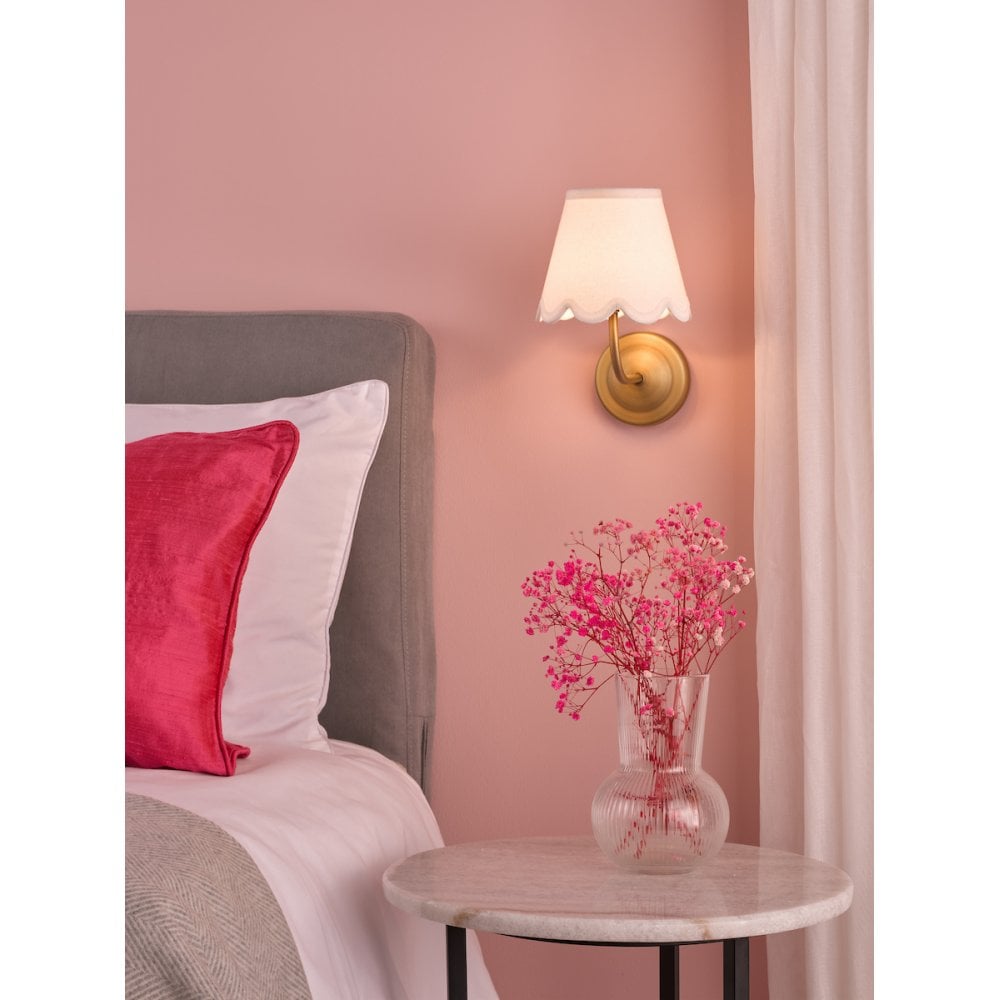 rechargeable brass wall light in pink bedroom with cream shade