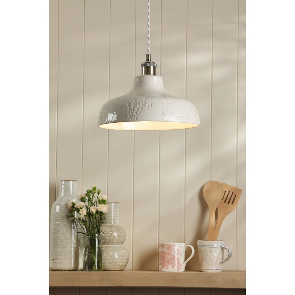 A cream pendant light over a kitchen side board