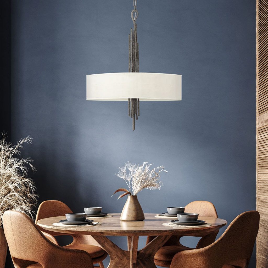 A ceiling light fitting with an authentic gothic or medieval feel but with a modern twist featuring a cream light shade, hanging in a dining room over a round dining table