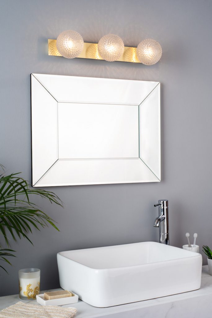 three prismatic glass globe lights above a mirror in a modern bathroom