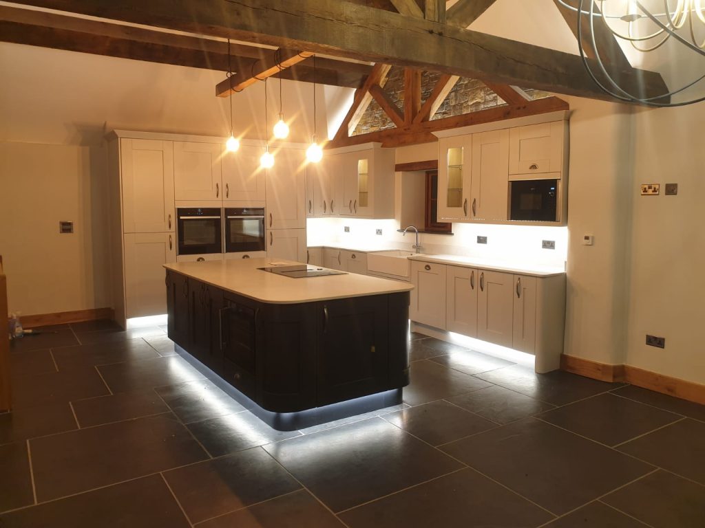 a modern kitchen with vaulted ceilings with hanging pendant lights
