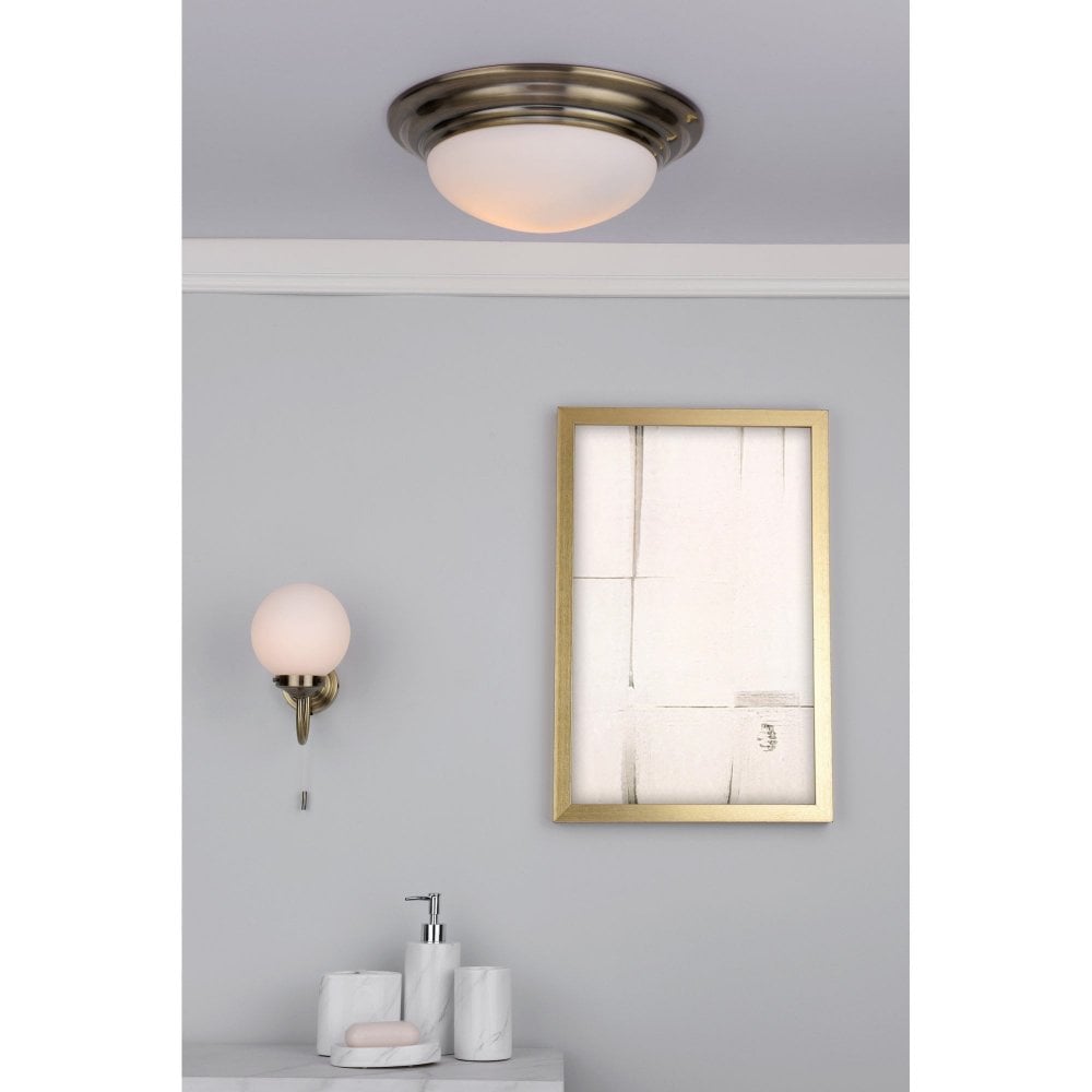 a matching traditional wall light and flush ceiling light finished in antique brass and opal glass for a heritage look