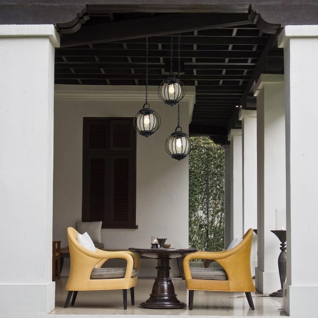 black and glass hanging globe pendants above a table and chairs