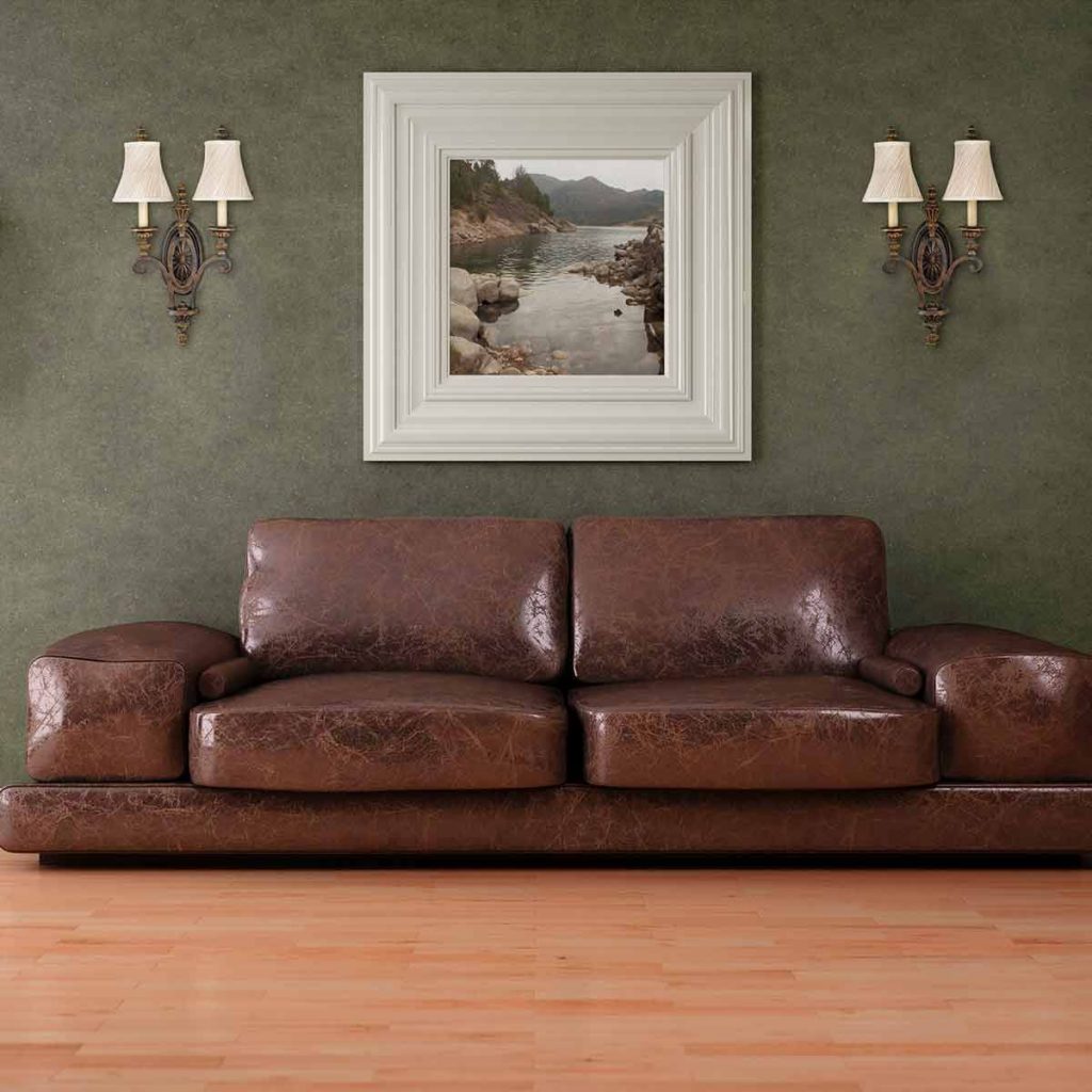 large ornate aged bronze wall sconces next to a painting above a sofa