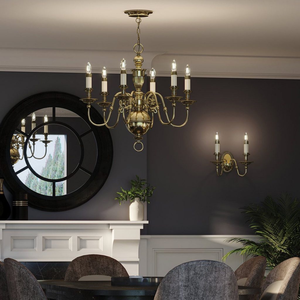 a traditional brass chandelier over a dining table with matching wall light