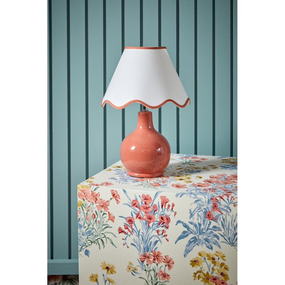 a vintage inspired pink table lamp with cream scalloped edged lamp shade