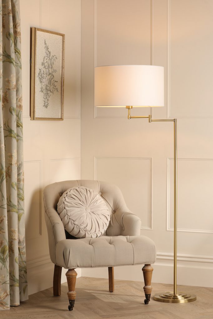 an adjustable floor lamp by arm chair in the corner of a living room