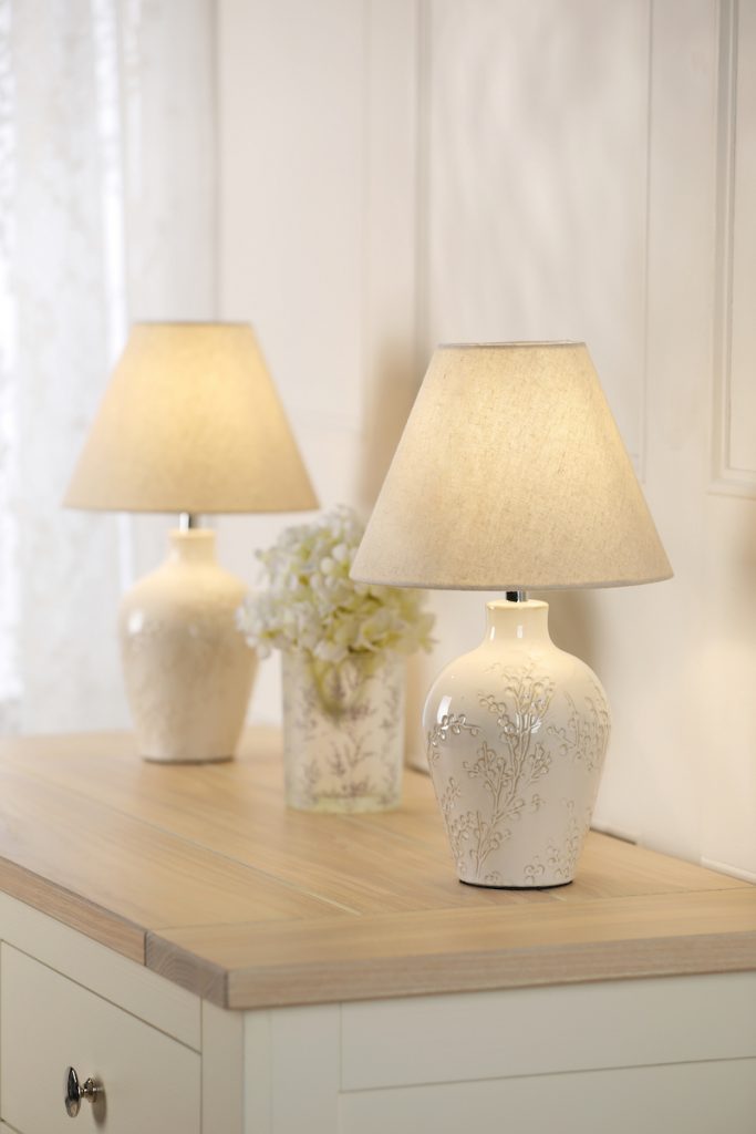 a pair of matching cream and white laura ashley table lamps on a side board