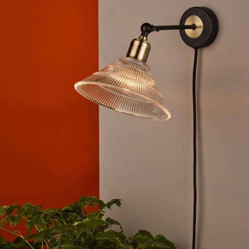 a plus in wall light with black base and ribbed glass cone shade
