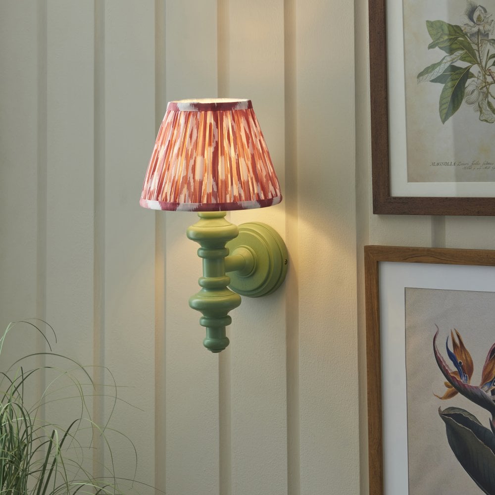 a green wall sconce with pink zig zag design fabric shade
