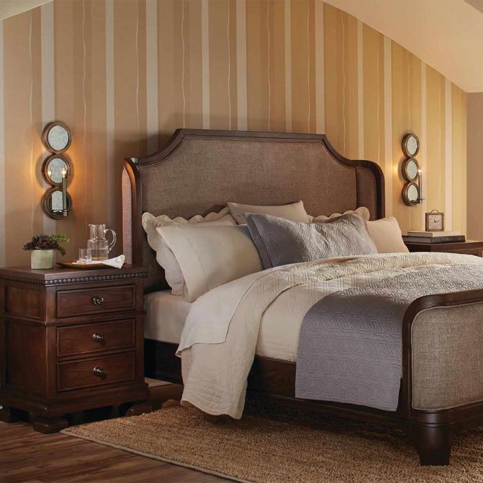 a bedroom with sloped ceilings that features decorative wall sconces