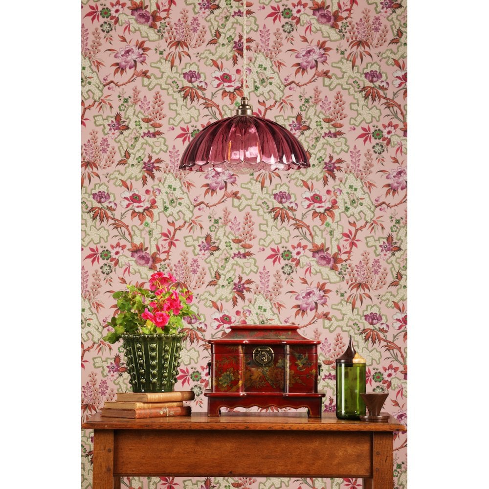 a decorative pink vintage inspired glass shade on a ceiling pendant over a sideboard