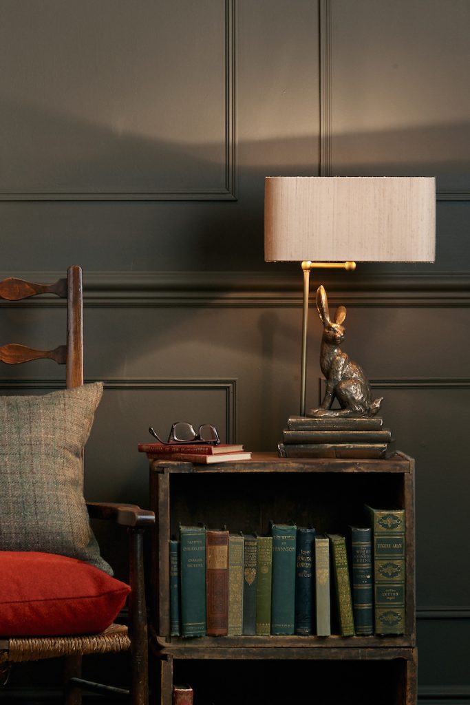 a bronze rabbit lamp beside a chair