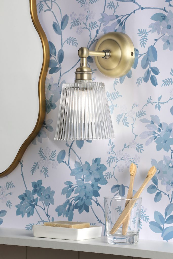 a bathroom wall light in a vintage brass finish with ribbed glass shade reminiscent of Victorian lighting