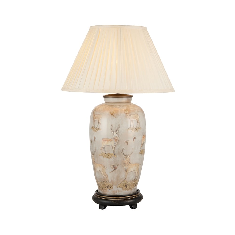 a large decorative ceramic table lamp with deer patterns and neutral linen tapered shade