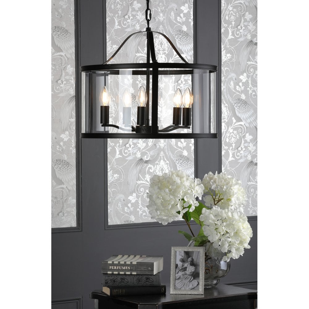 a matte black and glass drum chandelier pendant light above a table