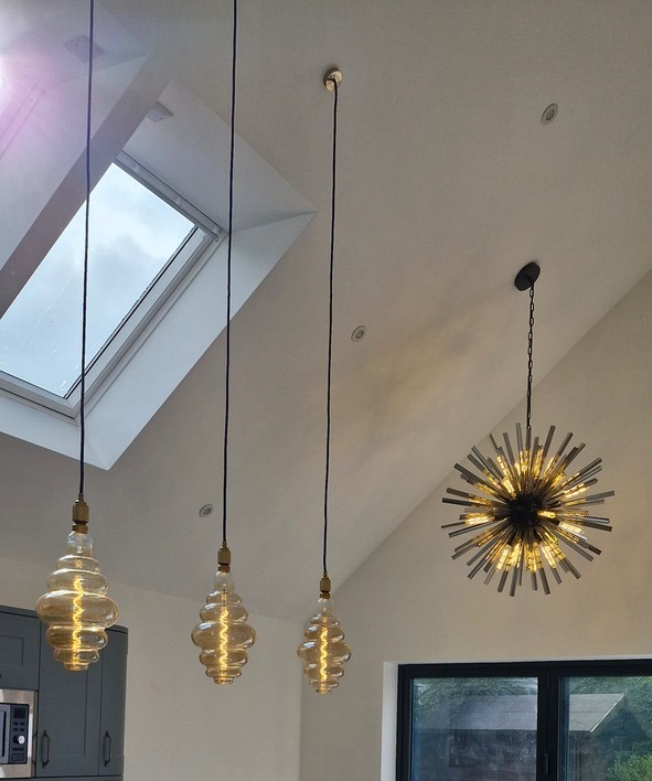 pendants lights suspended in front of velux skylight window on a sloped ceiling