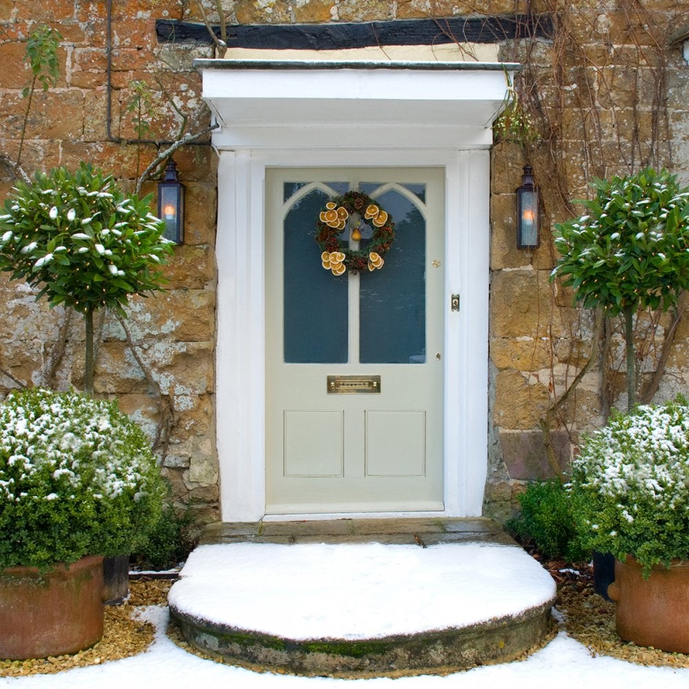 aged brass wall lanterns hanging beside a front door