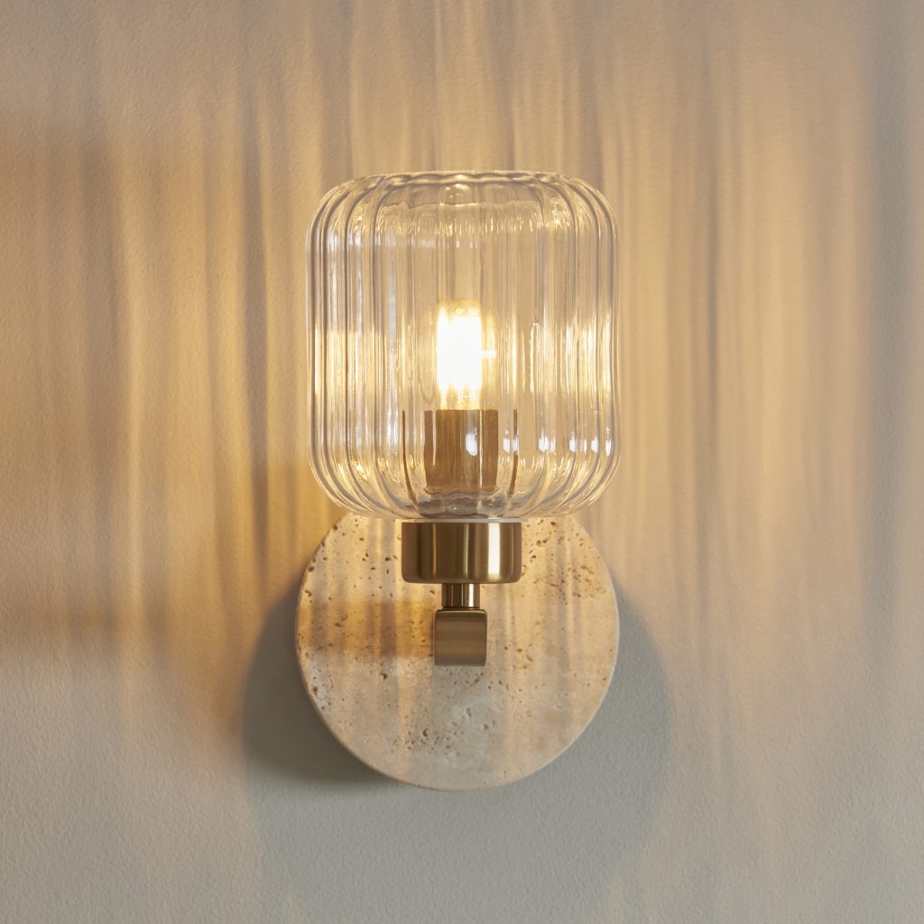 a stone wall light with ribbed glass