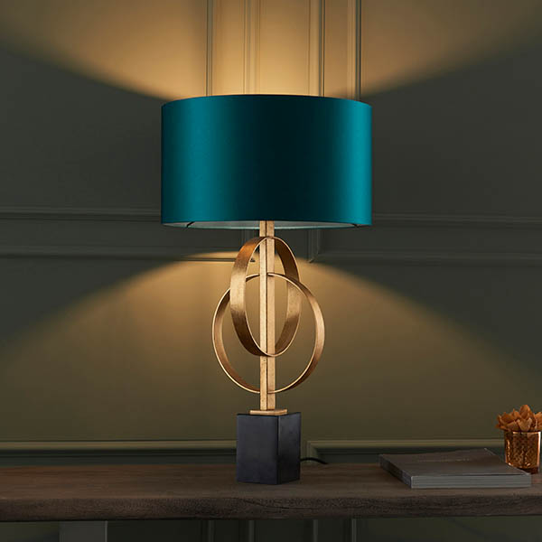 a sculptural table lamp with teal lampshade