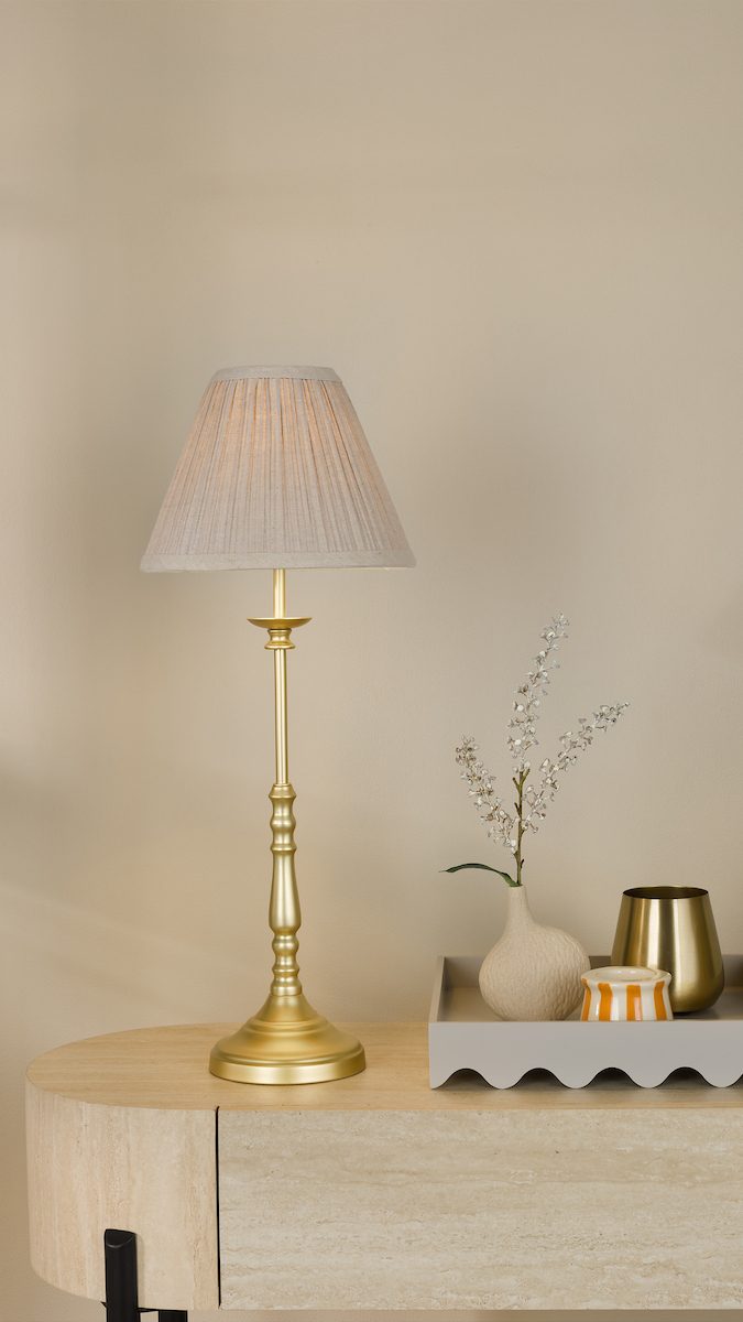 a traditional slender brass lamp base with aa neutral tapered pleated shade