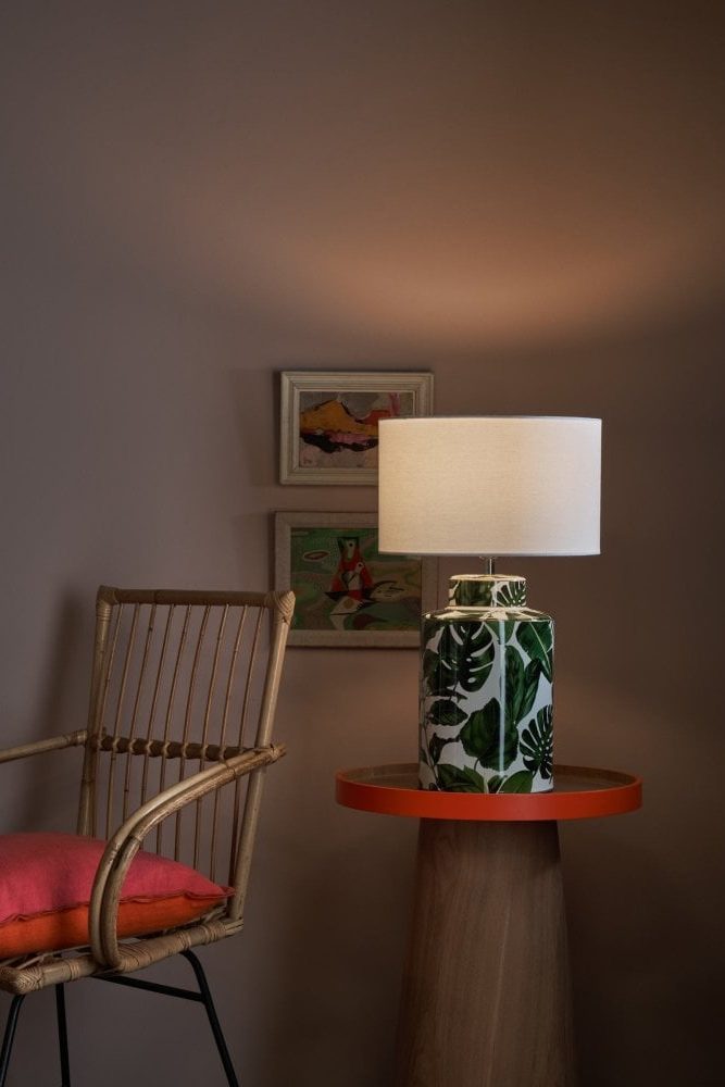 a leaf patterned ceramic lamp base with neutral drum shade