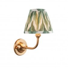 brass wall light with green zigzag pattern shade